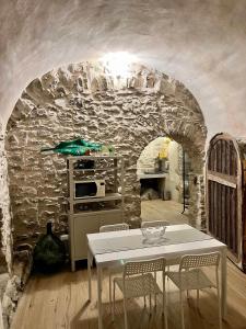 a kitchen with a table and a stone wall at La Finestra di Dante in Mulazzo