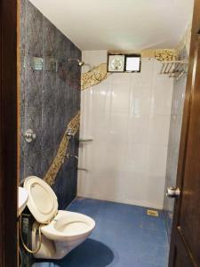 a bathroom with a toilet and a clock on the wall at 2BHK Affordable Apartment in North Goa - Baga and Anjuna Beach Nearby, Parra Road in Goa