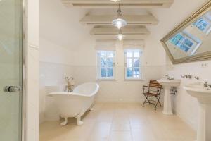 a white bathroom with a tub and two sinks at Landhaus Brook in Brook