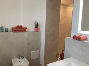 a bathroom with a sink and a toilet and towels at Alma - Art Luxus Modern Ambiente in Karlsruhe