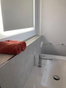 a bathroom with a red towel sitting on a counter at Alma - Art Luxus Modern Ambiente in Karlsruhe