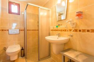a bathroom with a shower and a toilet and a sink at Orka World Hotel & Aquapark in Oludeniz