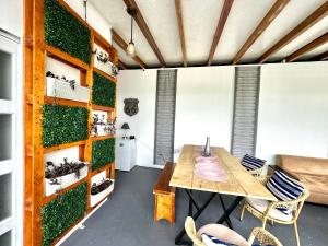 a room with a table and chairs and a green wall at Suite Agua - The Garden House - Independiente, Piscina, BBQ, Jardín, Terraza, Pedro Vicente Maldonado in Pedro Vicente Maldonado