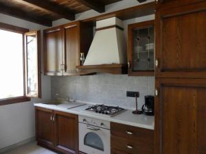 a kitchen with wooden cabinets and a stove top oven at Agriturismo La Vigna in Chiusanico