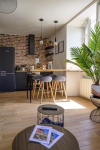 cocina abierta y sala de estar con pared de ladrillo en Appartement T2 - Vue imprenable sur la cathédrale en Quimper