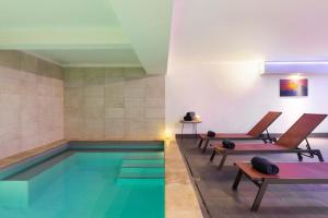 a pool with two chairs and a swimming pool at SOWELL RESIDENCES Pierre Blanche in Les Menuires