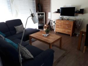Sala de estar con sofá azul y mesa de centro en Ankes Huus I, en Tossenserdeich