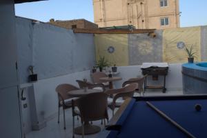 a pool table on a balcony with tables and chairs at Abeer Guest House in Luxor
