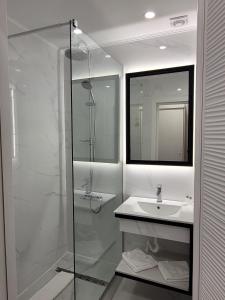 a white bathroom with a shower and a sink at Hotel Soimul in Poiana Brasov