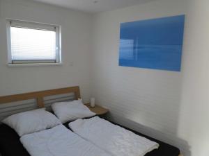 een slaapkamer met twee bedden en een raam bij Nordseeferienhaus Tossens III in Butjadingen