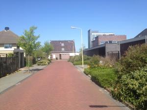 uma estrada de tijolos vermelhos numa cidade com edifícios em Fewo Klimduin Castricum em Castricum