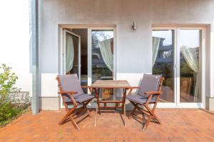 - une table en bois et 2 chaises sur la terrasse dans l'établissement Villa Wagenknecht, Ferienwohnung 02, à Boltenhagen