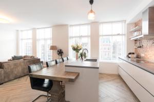 a kitchen and living room with a table and a couch at Kampervest Apartment Haarlem in Haarlem
