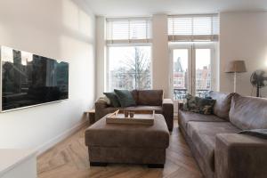 ein Wohnzimmer mit einem Sofa und einem Tisch in der Unterkunft Kampervest Apartment Haarlem in Haarlem