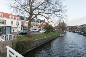 a river in a city with cars and buildings at Kampervest Apartment Haarlem in Haarlem