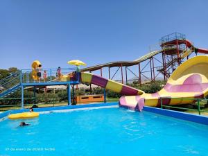 um escorrega aquático numa piscina com pessoas em Casa Felice Altovalsol em La Serena