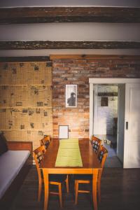 a dining room table with chairs and a brick wall at Ubytovanie Nitrianske Pravno in Prievidza