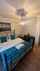 a bedroom with a large bed with blue sheets at Foca Antik Otel in Foça