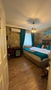 a bedroom with a bed and a desk in a room at Foca Antik Otel in Foça