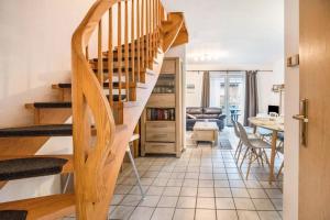 a living room with a wooden staircase and a dining room at Das Haus Konstantin heißt Sie und Ihre(n) Vierbeiner herzlich willkommen. in Neßmersiel