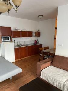 Habitación con cama y cocina con mesa en Útulný apartmán 50m od lyžiarskeho vleku Triangel en Donovaly