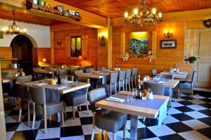 a restaurant with tables and chairs and a checkered floor at Hotel Floralp in La Clusaz