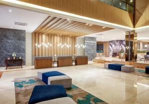 Oakwood Hotel & Apartments Taman Mini Jakarta في جاكرتا: لوبي فندق فيه كنب وغرفة انتظار