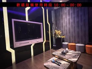 a living room with a tv and a table at Jinsha Motel in Taichung