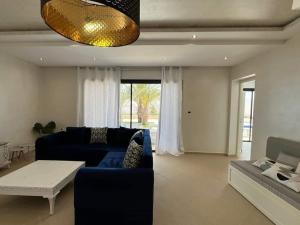 uma sala de estar com um sofá azul e uma mesa em Villa oasis em Arkou