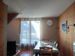 a dining room with a table and a clock on the wall at Chalet 6 / 8 personnes Super Dévoluy in Superdevoluy