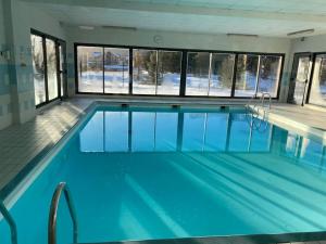 a large swimming pool with blue water in a building at Chalet 6 / 8 personnes Super Dévoluy in Superdevoluy