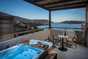 a jacuzzi tub on the balcony of a house at Elounda Infinity Exclusive Resort & Spa - Adults Only in Elounda