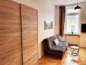 a living room with a chair and a sliding door at Kienmayer Apartment Vienna in Vienna
