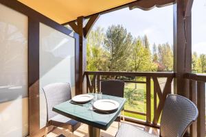 einen Tisch und Stühle auf einem Balkon mit Aussicht in der Unterkunft Le Swing - Résidence avec piscine chauffée in Deauville