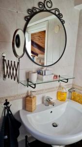 ein Badezimmer mit einem weißen Waschbecken und einem Spiegel in der Unterkunft the Wooden Roof in Baronissi