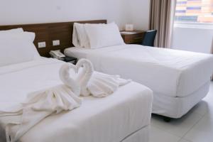 Dos camas en una habitación de hotel con toallas. en Cris Inn Tagum, en Tagum