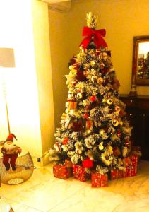Palazzo Firenze في نابولي: شجرة عيد الميلاد مع وجود هدايا تحتها في غرفة