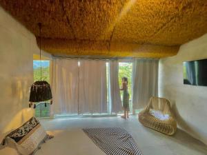 a woman standing in a room looking out the window at Casa Lamia in Manuel Antonio