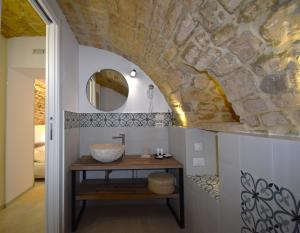 een badkamer met een wastafel en een stenen muur bij B&B Cuore Barocco in Ragusa
