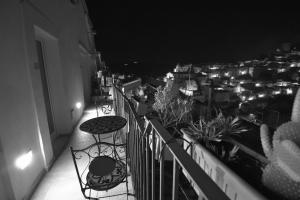 a balcony with a table and chairs at night at B&B Cuore Barocco in Ragusa