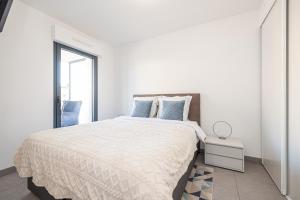 Un dormitorio blanco con una cama grande y una ventana en Beautiful New Apartment en Menton