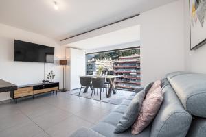 a living room with a couch and a table at Beautiful New Apartment in Menton