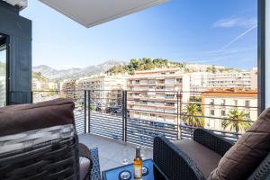 a balcony with chairs and a view of a city at Beautiful New Apartment in Menton