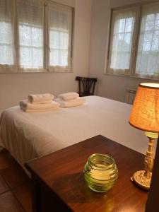 1 dormitorio con 1 cama con mesa y lámpara en La Casa de Letri - Alojamiento rural en Lamuño, en Lamuño