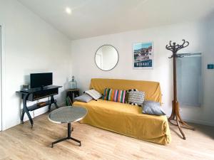 een woonkamer met een bank en een tafel bij Ilbarritz, T2 proche plage/parking/terrasse in Bidart