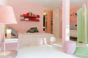 a pink bedroom with a bed and a lamp at Stylish Garden-Gem by Lake: Pet-Friendly & Central in Zürich