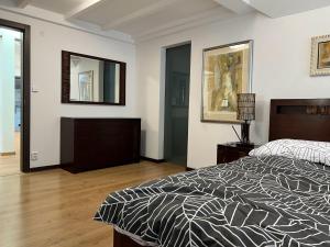 a bedroom with a bed and two mirrors on the wall at Lux Apartmán Centrum in Topoľčany