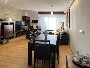 a dining room and living room with a table and chairs at Lux Apartmán Centrum in Topoľčany