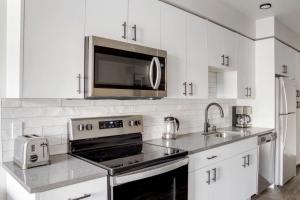 a white kitchen with a stove and a microwave at Lower Queen Anne 1br w game room garden SEA-698 in Seattle