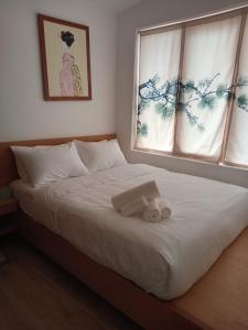 a bedroom with a white bed with a window at Nathy Villa in Khu Chi Lăng
